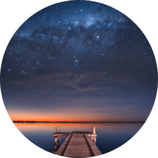 milky way over still waters and pier